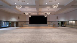 A large event venue with modern lighting, a dance floor, and stage.